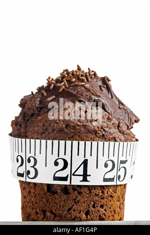 Verticale foto a colori di una torta al cioccolato con un metro a nastro avvolto intorno ad esso Foto Stock