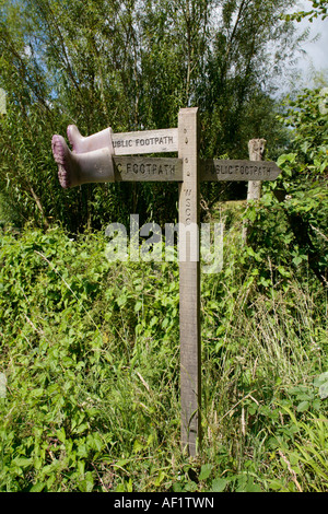 Bambino wellies rosa appeso sul cartello in legno Foto Stock