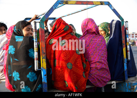 Femmine indiane che vanno a lavorare dietro di chakda - moto rickshaw taxi, Diu, Gujarat, India Foto Stock