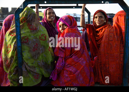 Femmine indiane che vanno a lavorare dietro di chakda - moto rickshaw taxi, Diu, Gujarat, India Foto Stock