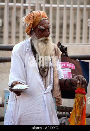 L'uomo santo indiano che mendica fuori del tempio di Dwarkadhish, Dwarka, Gujarat, India Foto Stock