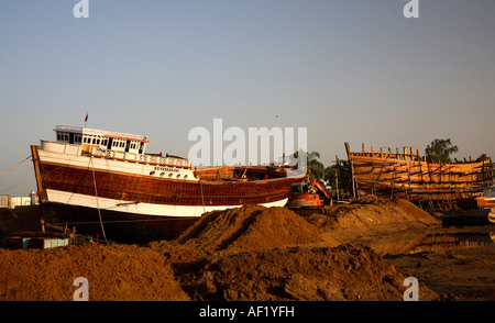 Barche su terreno asciutto a cantiere navale di legno, Mandvi, Kutch, Gujarat, India Foto Stock