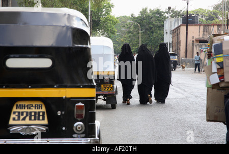 Tre donne musulmane indiane che indossano niqab camminando lungo la strada, Pune, India Foto Stock