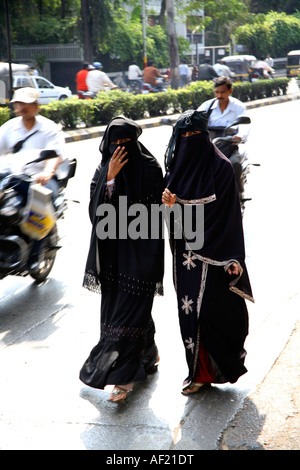 Due donne musulmane che indossano nero niqab camminando strade di Pune, India Foto Stock