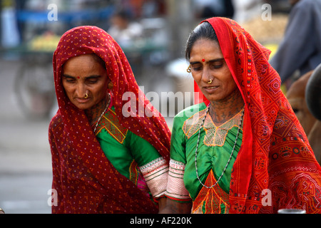 Rabari donne tribali con tatuaggi del collo che scelgono prodotti di mercato, una, Gujarat, India Foto Stock