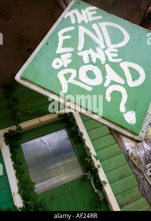 Un verde 'fine della strada?" dipinta a mano segno esterno di una casa abbandonata in Nuova Zelanda Foto Stock