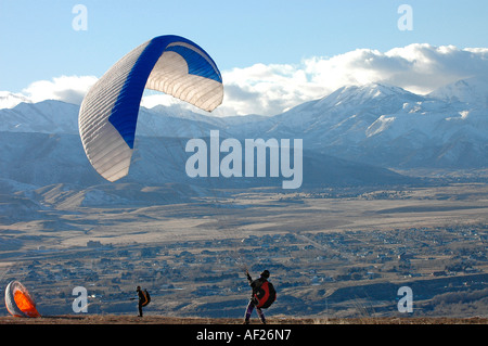Due para i piloti di parapendio di preparare la loro para glider craft riempimento loro para alianti con vento sempre pronto a sollevare Foto Stock