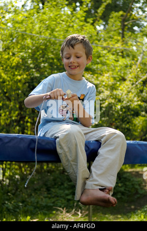 8 anno vecchio ragazzo è seduto nel giardino carving Foto Stock