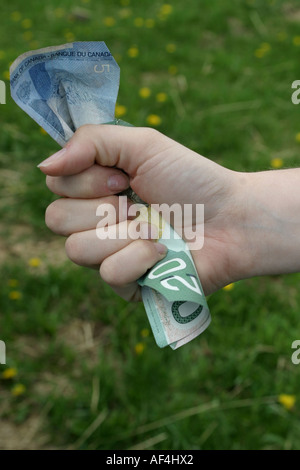 Mano chiusa pugno pieno di denaro Foto Stock