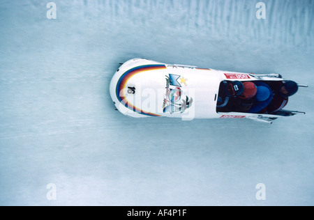 Quattro uomini di toboga banca team disco attorno ad una curva verticale in corrispondenza di velocità sulla cresta Run St Moritz Engadina svizzera Foto Stock