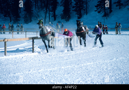 Cavallo e ski racing skijoring su una curva sulla pista del lago ghiacciato a St Moritz Engadina svizzera Foto Stock
