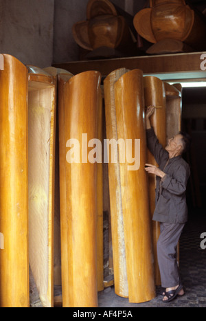 Un uomo cinese mette i tocchi finali a colorati rotondi bare impilate su fine in un workshop nei tardi anni settanta di Hong Kong Foto Stock