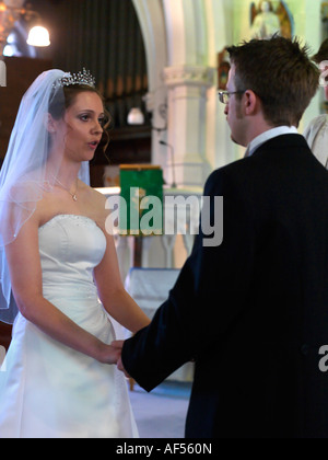 Sposa e lo sposo lo scambio di voti durante un matrimonio anglicano Service Surrey in Inghilterra Foto Stock