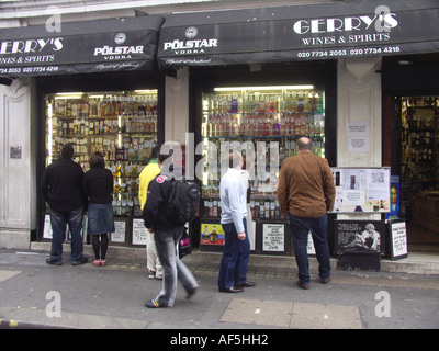 Persone che guardano la finestra di visualizzazione del Gerry off vecchia licenza Compton Street Soho Londra Foto Stock