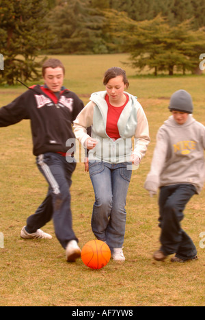 Un gruppo di ragazzi adolescenti e le ragazze a giocare a calcio in un Park Regno Unito Foto Stock