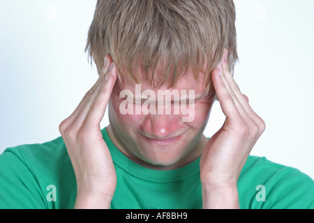 Una fotografia stock di un giovane adulto maschio con un mal di testa Foto Stock