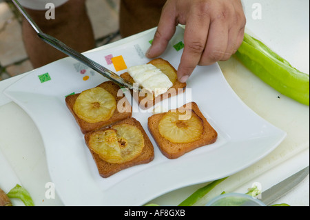 L'uomo preparando quattro pintxos sulla piastra bianca Plaza Arenal Bilbao Pais Vasco Paese Basco in Spagna Foto Stock