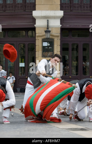 Uomo basco sventola bandiera nazionale, la Ikurrina, durante il ballo folk Plaza Arriaga Bilbao Pais Vasco Paesi baschi Spagna Europa Foto Stock