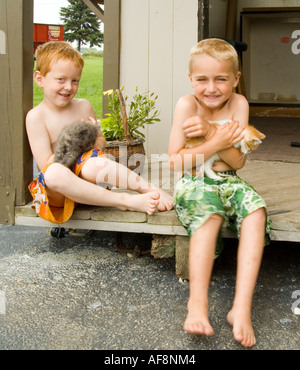 Farm boys e gattini Foto Stock