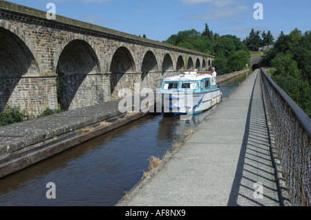 Una barca sul Llangollen Canal passa sopra Chirk aquaduct accanto al viadotto ferroviario Foto Stock