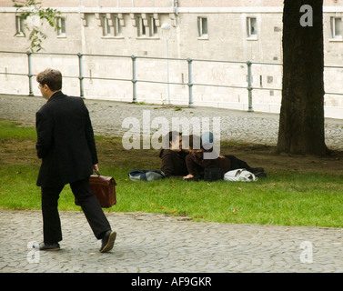 Coppia giovane godere di ogni altro mentre un uomo anziano passa da. Foto Stock