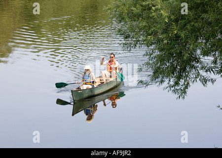 Uomo e donna colorati da indossare i giubbotti di salvataggio e utilizzando le piastre rosso paddling in alluminio canoa canadese lungo il fiume Wye Regno Unito Foto Stock