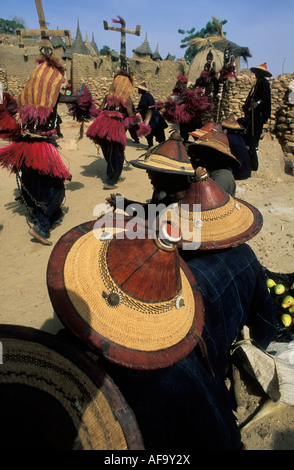 Dogon uomini indossando cappelli tradizionali guardare i ballerini nei pressi di Bandiagara scarpata, Paese Dogon del Mali Foto Stock