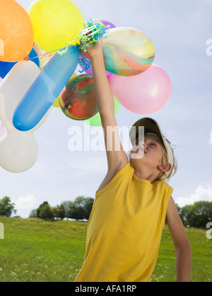 Ragazzo holding palloncini, ritratto Foto Stock