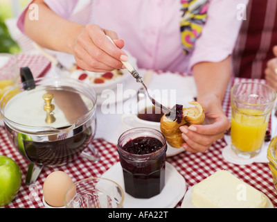 Donna messa jam su brioche Foto Stock