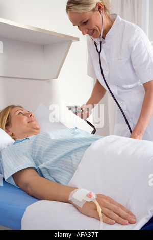 L'infermiera controllando la pressione del sangue del paziente femmina Foto Stock