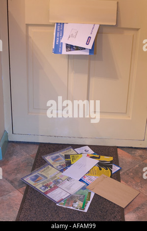 Post proveniente attraverso una buca delle lettere di una casa porta anteriore e giacente sul tappetino Foto Stock