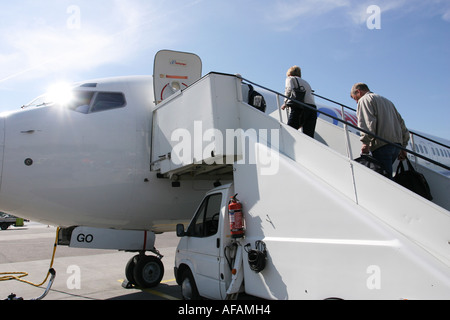 I turisti di salire a bordo di un aereo con la scala su un piccolo camion Foto Stock