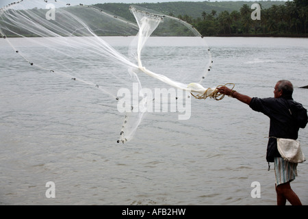 Pescatore di Goan gettando cast net presso Tiracol fiume vicino a Spiaggia Querim Pernem Goa nord India Asia Foto Stock