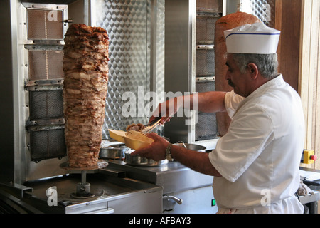 L'uomo la preparazione di Döner Kebab in take-away ristorante Foto Stock