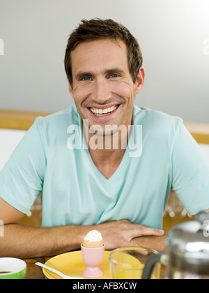 Uomo seduto al tavolo per la colazione Foto Stock