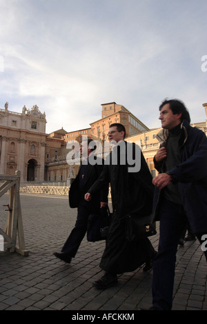 Tre giovani sacerdoti a piedi attraverso Piazza San Pietro nella Città del Vaticano. Foto Stock