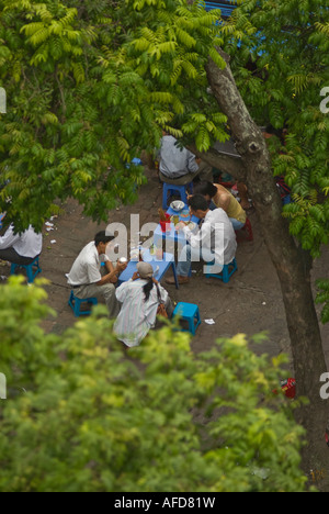 Un gruppo di lavoratori di consumare la colazione in una bancarella di strada Hanoi Vietnam Foto Stock