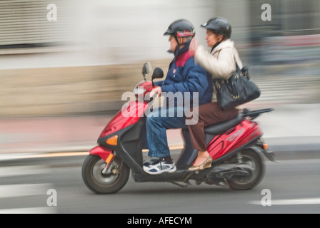Per i ciclomotori muniti di piloti su una strada di città di Nerja spagna Foto Stock