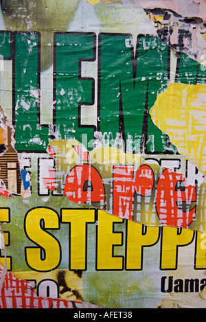 Vecchi manifesti stracciati con lettere in grassetto in giallo rosso e verde Foto Stock