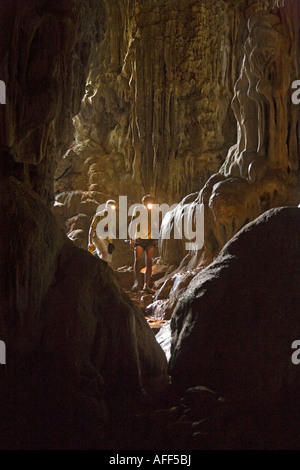 I turisti con le torce esplorare la galleria principale nel Tham Phu Kham (Poukham) grotta bocca, vicino a Vang Vieng. Laos Foto Stock