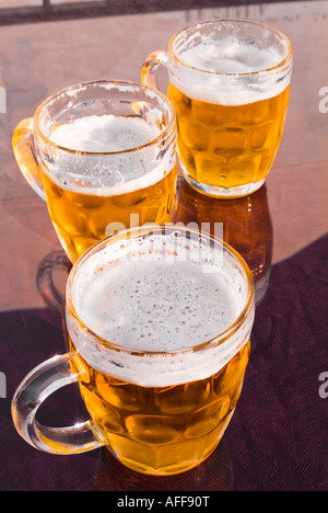Tre tazze di vetro pieno di birra seduti sul tavolo Foto Stock