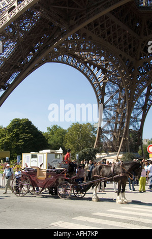Carro trainato da cavalli sotto la Torre Eiffel a Parigi Foto Stock