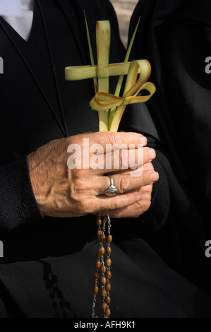 Israele Gerusalemme Sainte Anne Chiesa la Domenica delle Palme processione cattolica close up di una monaca s mano azienda 2 croci fatte di palm leav Foto Stock