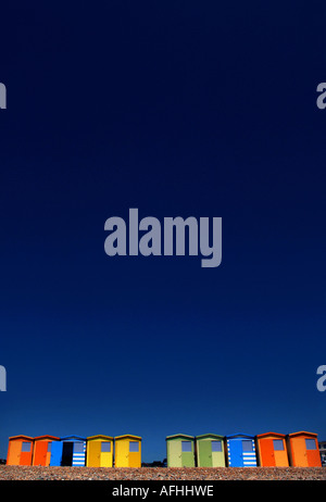 Cabine sulla spiaggia, sulla costa del Sussex bagnata dal sole mattutino set contro il blu profondo del cielo estivo. Foto da Jim Holden. Foto Stock