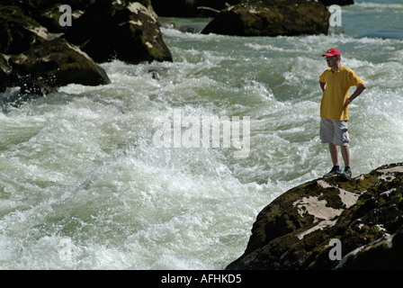 Lone figura in piedi su un promontorio roccioso guardando le rapide del fiume Vrbas, Bosnia Erzegovina. Foto Stock