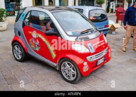 Red Smart mini auto parcheggiate in via principale di Chioggia Italia Foto Stock