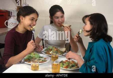 3 giovani ragazze adolescenti di mangiare cibo sano Foto Stock