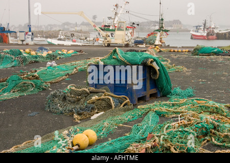 Le reti da pesca stabiliti sul Quayside in Loctudy, Bretagna Francia con barche da pesca in background Foto Stock