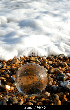 Palla di vetro sfera di cristallo sulla spiaggia ghiaiosa Foto Stock