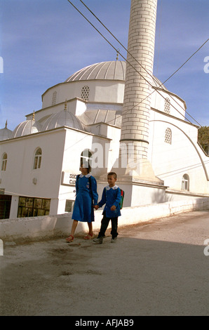 I bambini di ritorno da scuola nella parte anteriore della moschea nel piccolo villaggio rurale nel sud-ovest della Turchia. Foto Stock